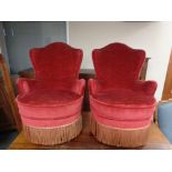 A pair of salon armchairs in red tasselled upholstery