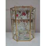 A brass and glass display cabinet containing crystal ornaments, Swarovski and others.