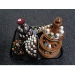 A tray of five wooden thimble display stands and a quantity of china and metal thimbles