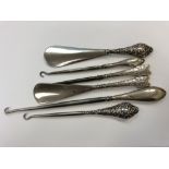 Two silver mounted shoe horns and four similar boot pulls