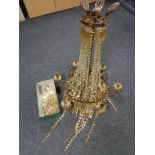 An antique metal six way light fitting with glass drops