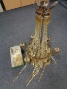 An antique metal six way light fitting with glass drops