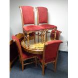 A circular Syrian style ornate glass topped pedestal dining table and six chairs upholstered in red