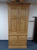 A pine double door wardrobe fitted with three drawers beneath, width 100 cm, depth 60 cm,