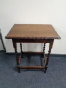 An Edwardian oak occasional table on barley twist legs