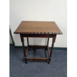 An Edwardian oak occasional table on barley twist legs