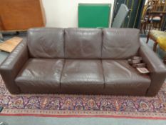 A contemporary brown leather three seater settee