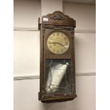 An early twentieth century oak eight day wall clock