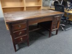 An Edwardian oak twin pedestal desk fitted seven drawers
