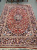 A Kashan rug, central Iran, on red ground 300 cm x 202 cm.