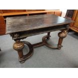 A nineteenth century carved oak library table on bulbous legs and x-frame under stretcher