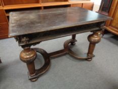A nineteenth century carved oak library table on bulbous legs and x-frame under stretcher