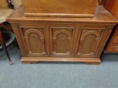 An oak low sideboard fitted with three doors