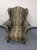 A wing backed armchair in classical upholstery