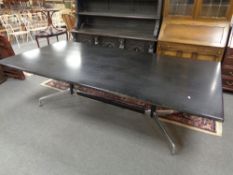 A contemporary black ash conference table on chrome under stretcher, length 240 cm.