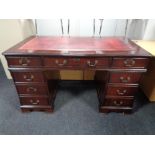 A good quality reproduction mahogany twin pedestal desk with tooled red leather top