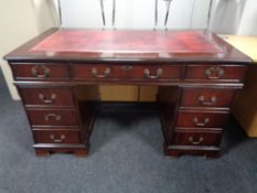 A good quality reproduction mahogany twin pedestal desk with tooled red leather top