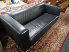 A black faux leather two seater settee