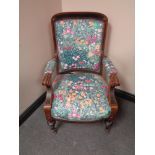 A nineteenth century walnut armchair in floral upholstery raised on castors