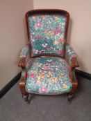 A nineteenth century walnut armchair in floral upholstery raised on castors