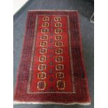 An Afghan design rug on red ground