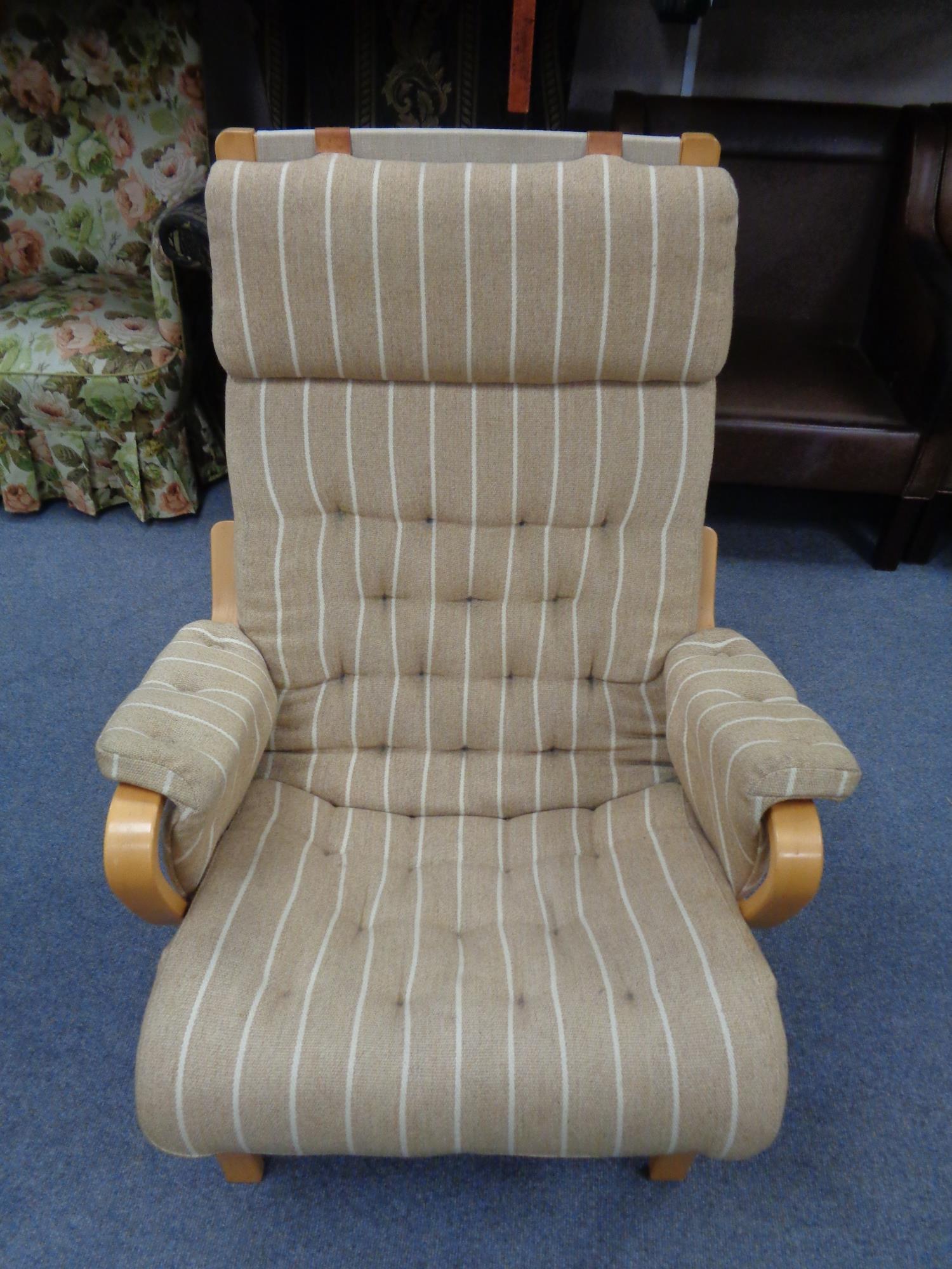 A continental easy chair in striped buttoned upholstery