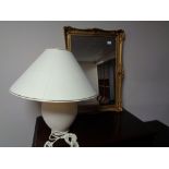 A gilt framed mirror and a pottery table lamp with shade