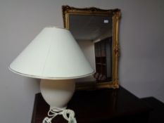 A gilt framed mirror and a pottery table lamp with shade
