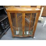 A walnut bow fronted display cabinet