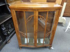 A walnut bow fronted display cabinet