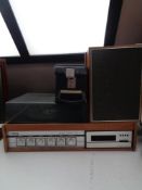 A Tellux teak cased turn table with eight track stereo together with a pair of teak cased speakers