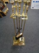 Four piece brass companion set on stand and a pair of miniature brass candlesticks