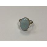 A silver dress ring with opalescent stone,