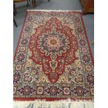 A machine made Persian design carpet on red ground 242 cm x 161 cm