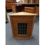 An oak wall cabinet with leaded glass door