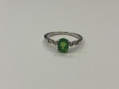 A silver dress ring set with a green stone,