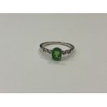 A silver dress ring set with a green stone,