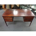 A mid century Danish stained beech writing desk fitted with six drawers