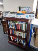 A set of mahogany effect open bookshelves containing books and two further boxes of books