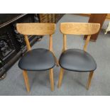 A set of four Danish oak dining chairs with black vinyl seats