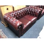 A Chesterfield style red buttoned leather two seater settee