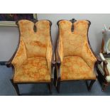 A pair of early twentieth century carved beech framed armchairs in orange upholstery