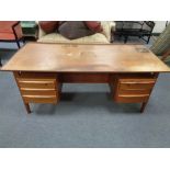 A mid century continental teak low desk fitted with six drawers