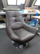 A brown leather armchair on swivel base