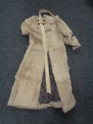 A white mink fur coat with leather belt