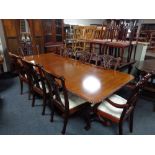 A reproduction Victorian style twin pedestal dining table with two leaves and eight Hepplewhite