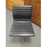 A Vitra Charles Eames designed Alu swivel chair upholstered in black leather with chrome frame