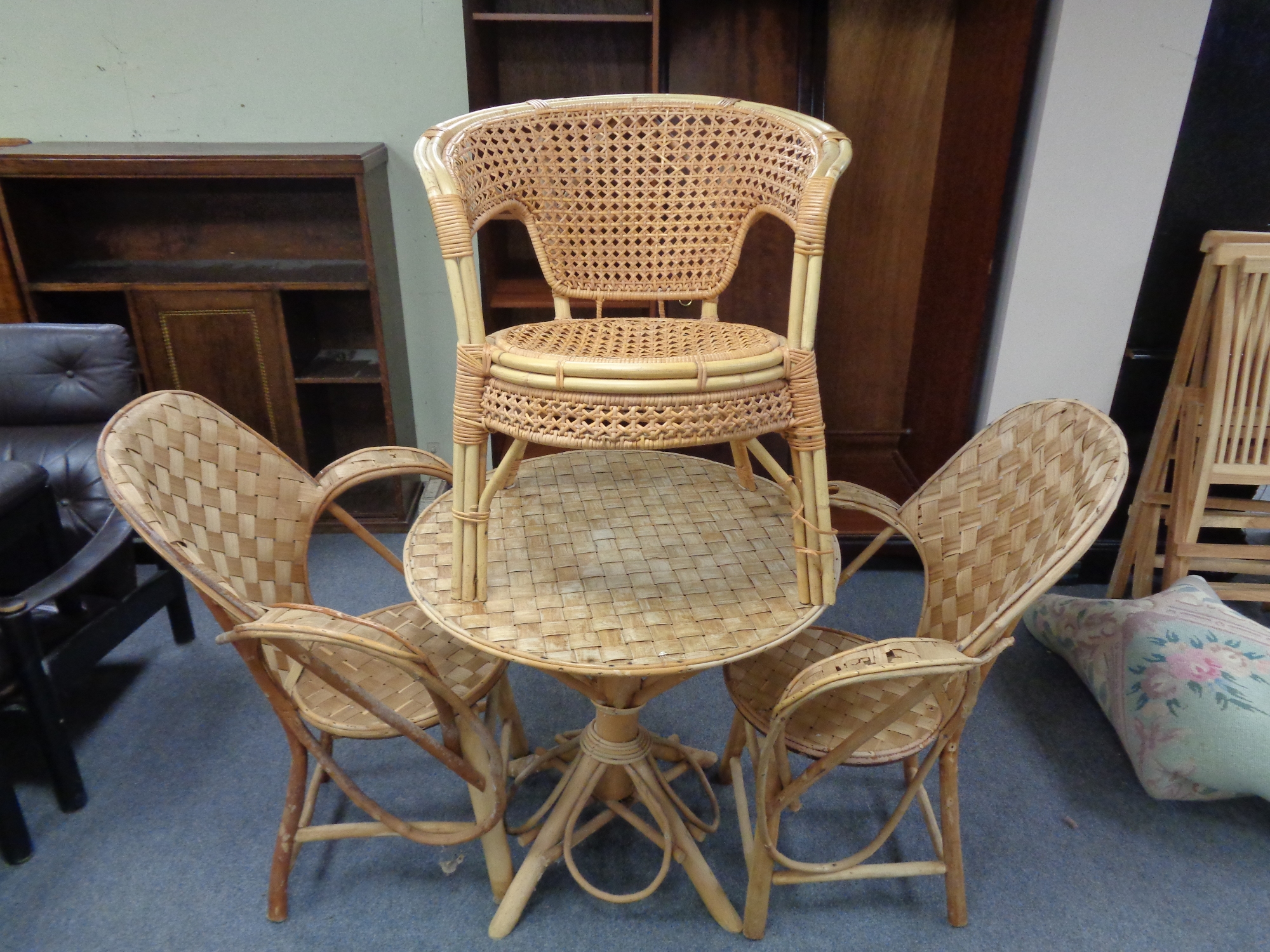 A wicker conservatory table and three similar chairs