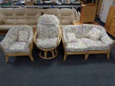 A three piece bamboo and wicker suite with floral cushions