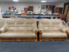 A wooden framed leather three seater settee and matching two seater settee with fitted drawers